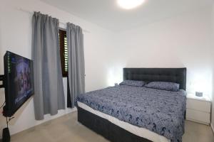 a bedroom with a bed and a flat screen tv at Apartment Elena in Soline