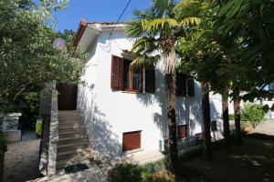 a house with palm trees in front of it at Apartment Elena in Soline