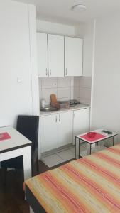 een kleine keuken met witte kasten en een tafel bij Apartmani Borko 3-3 in Loznica