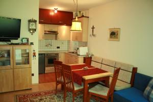 Ferienwohnung Thermen في ميرانو: غرفة معيشة مع طاولة ومطبخ