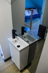een badkamer met een witte wastafel en een spiegel bij Turystyczna Suite in Ostróda