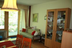 Ferienwohnung Thermen في ميرانو: غرفة معيشة مع أريكة وخزانة زجاجية