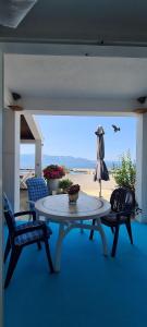 einen Tisch und Stühle auf einer Terrasse mit Blick auf den Strand in der Unterkunft Apartments Lanterna in Sućuraj