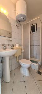 łazienka z toaletą i umywalką w obiekcie Apartments Lanterna w mieście Sućuraj