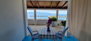 a table with blue chairs and a table with flowers on it at Apartments Lanterna in Sućuraj