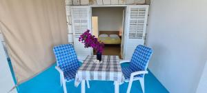 a table with two chairs and a vase with flowers on it at Apartments Lanterna in Sućuraj