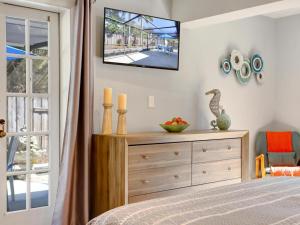 una camera da letto con un letto e una TV a parete di Lake Park Cottage a Naples