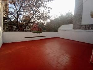 Habitación con suelo rojo y pared blanca en Refugio Porteño en Buenos Aires