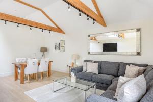 a living room with a couch and a table at The Cowshed in Farmborough