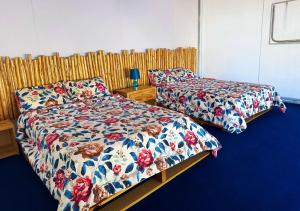 two beds sitting next to each other in a bedroom at Nazca Lodge in Nazca