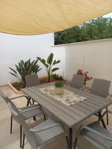 un tavolo e sedie in legno su un patio di Dimora Stemar a Taviano