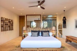 a bedroom with a large white bed with a ceiling fan at Hotel Villas Flamingos in Holbox Island