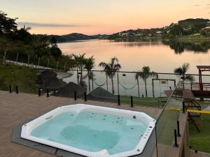 een hot tub op een patio naast een meer bij Surreal Igaratá Pousada in Igaratá