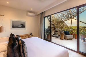 1 dormitorio con cama y ventana grande en Hotel Villas Flamingos, en Isla Holbox