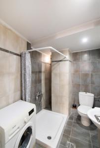 a bathroom with a washing machine and a toilet at Summer Breeze apartment in Póndi