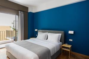 ein blaues Schlafzimmer mit einem Bett mit blauer Wand in der Unterkunft Nileos House in Athen
