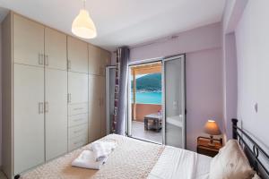 a bedroom with a bed and a view of the ocean at Summer Breeze apartment in Póndi