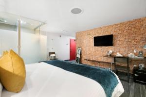 a bedroom with a large bed and a brick wall at Inn 15 Brewery Loft Suites in Kingsville