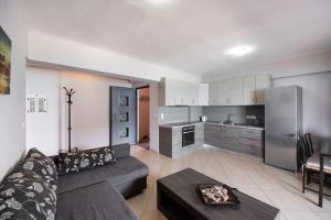 a living room with a couch and a kitchen at Summer Breeze apartment in Póndi