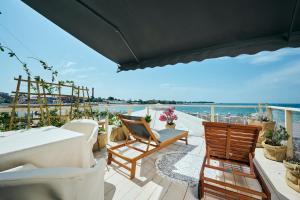 乌马格San Marco Rooms Umag的带桌椅和海景的阳台