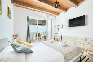 San Marco Luxury Rooms Umag في أوماغ: غرفة نوم بيضاء مع سرير كبير ونافذة
