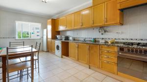 a kitchen with wooden cabinets and a table in it at Villas Boas House Silves in Silves