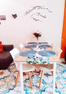 a dining room with a table with white chairs at Casa Lego Napoli in Naples
