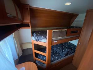 mały pokój z 2 łóżkami piętrowymi w łodzi w obiekcie Luksusowy Kemping w mieście Leśna