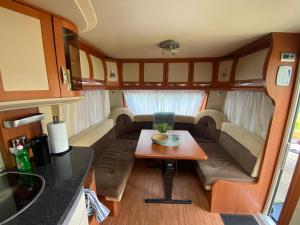 a small living room with a table in a rv at Luksusowy Kemping in Leśna