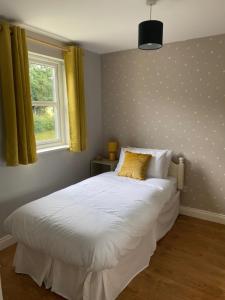 a bedroom with a white bed with a polka dot wall at No 3 Aughrim Holiday Village in Aughrim