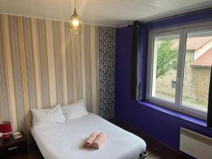 Un dormitorio con una cama con un par de zapatillas. en Appartement à Limoges, en Limoges