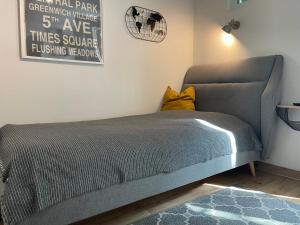 ein Schlafzimmer mit einem grauen Sofa und einem gelben Kissen in der Unterkunft Hofquartier Schwerin in Schwerin