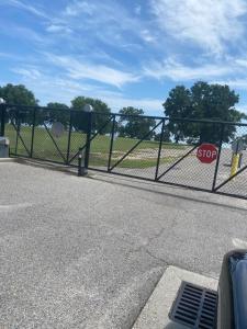 a gate with a stop sign in front of a road at Oak Shores. in Biloxi