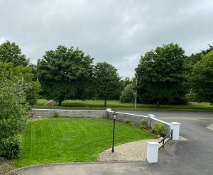 un parque con una valla y un campo de césped en Laurel Lodge en Droichead an Chaisleáin