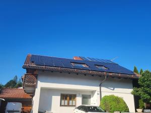 una casa con paneles solares en el techo en Haus Lärche - Die Ferienwohnung, en Wolfratshausen