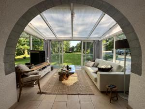 an archway in a living room with a couch and a tv at La Source Marie-Elise in Stavelot