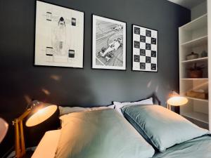 a bedroom with a bed and three pictures on the wall at La Source Marie-Elise in Stavelot