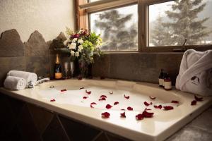una vasca da bagno con petali di rosa rosso di A Bear and Bison Country Inn a Canmore