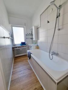 a white bathroom with a tub and a sink at Haus No. 48 in Friesenheim