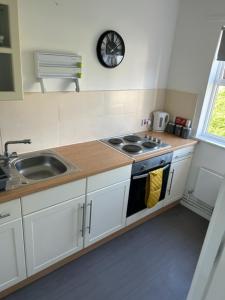 a kitchen with a sink and a stove at St Pauls Court Apartments in Stockton-on-Tees