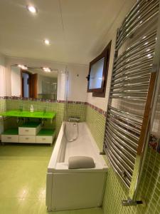 baño verde con bañera y lavabo verde en Villa Reencuentro, en Mojácar
