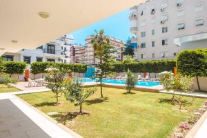 un patio con árboles y una piscina en un edificio en ABR 5 Residence, en Alanya