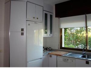 a kitchen with a white refrigerator and a window at casa cumial in Ourense