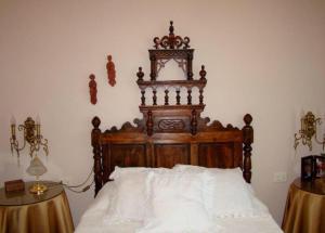 een bed met een houten hoofdeinde in een slaapkamer bij casa cumial in Ourense
