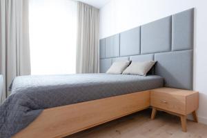 Schlafzimmer mit einem Bett mit einem großen Kopfteil in der Unterkunft Apartament Szafirowy by Major Domus Club in Dziwnów