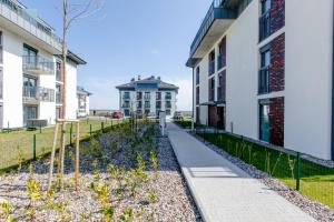 ein Gehweg zwischen zwei Gebäuden mit einem Gebäude im Hintergrund in der Unterkunft Apartament Szafirowy by Major Domus Club in Dziwnów