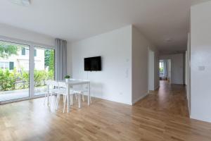 una sala de estar blanca con mesa y sillas en T&K Apartments - Bergisch Gladbach - 3 Comfortable Apartments - 18 min to Fair Messe Cologne, en Bergisch Gladbach