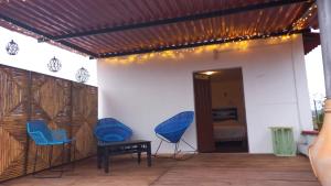 een patio met 2 blauwe stoelen en een slaapkamer bij Casa Andivi Ruta Dominica in Yanhuitlán