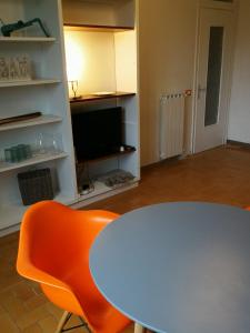 a white table and a orange chair in a room at Tuscany, Pontremoli, Italy Swallows Court Lovely home sleeps 2 to 4 people in Pontremoli