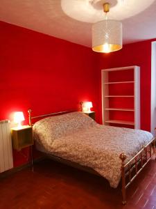 1 dormitorio rojo con 1 cama y 2 lámparas en Tuscany, Pontremoli, Italy Swallows Court Lovely home sleeps 2 to 4 people, en Pontremoli